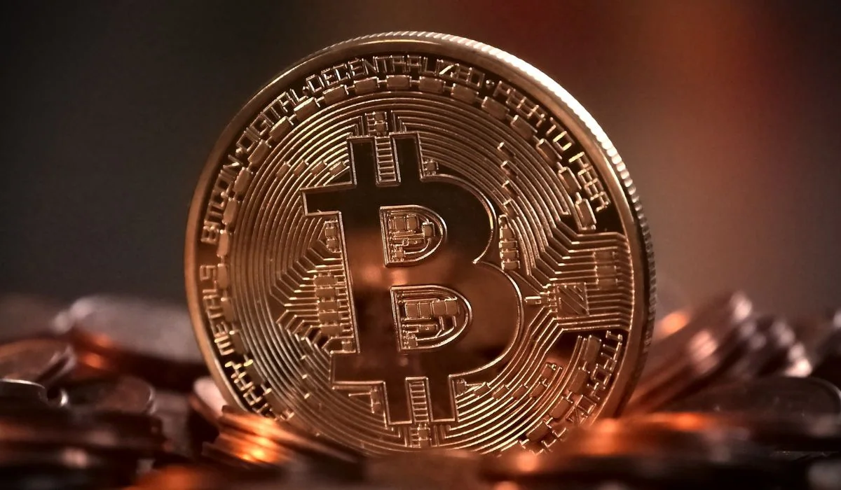 A Bitcoin stands out with blurred coins in the background.