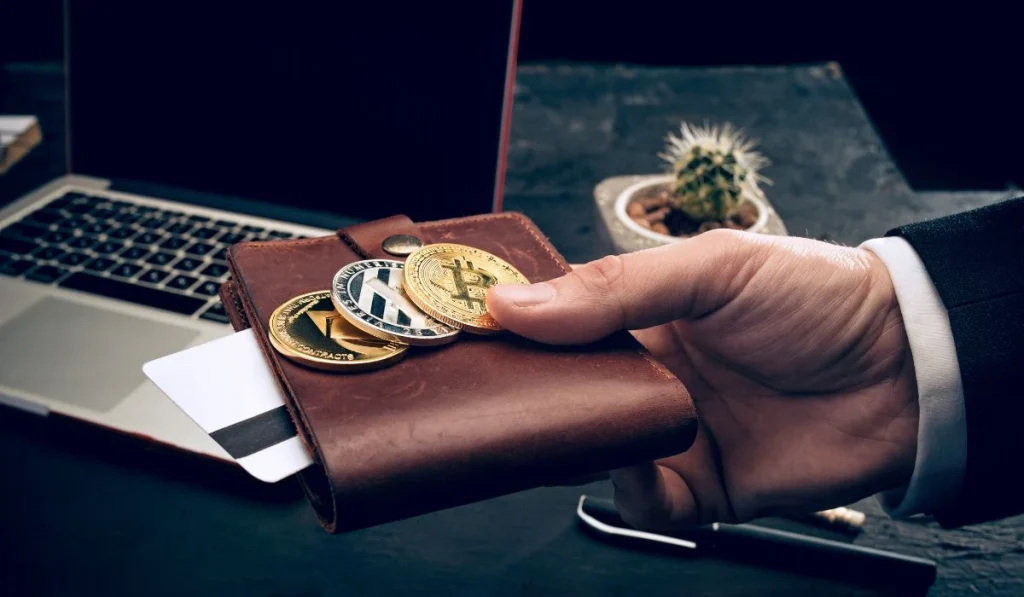 A person holding a wallet and cryptocurrency coins